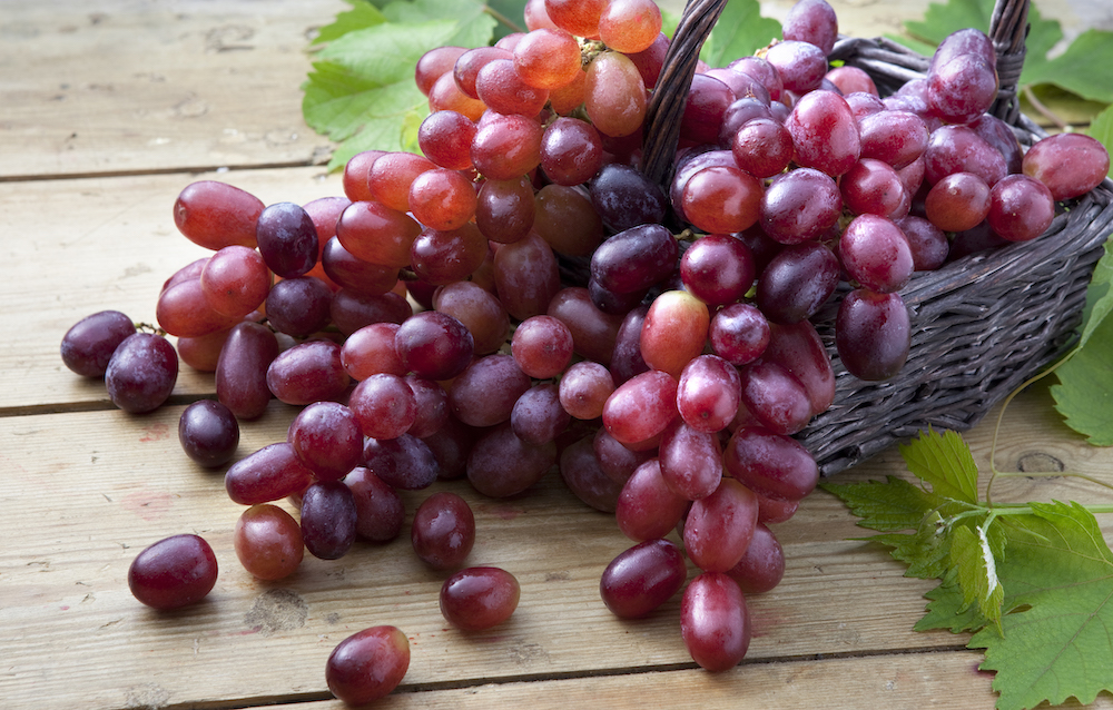 Image of a cluster of red grapes in a basket.