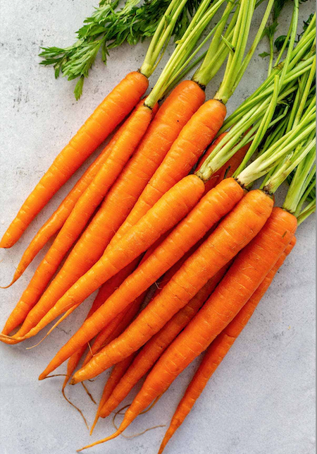 An image of a bunch of carrots on a table top.