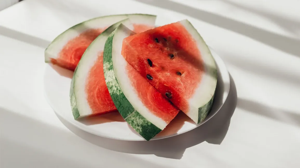 Image of four slices of watermelon on a plate.